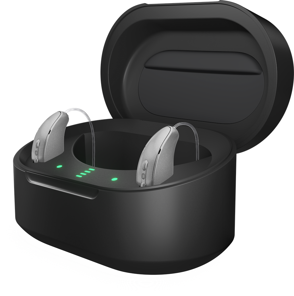 Rechargeable hearing aids resting in a black charging case with green LED indicators.