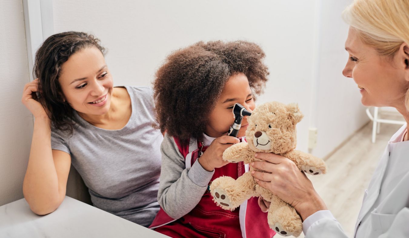 young girl holding otoscope