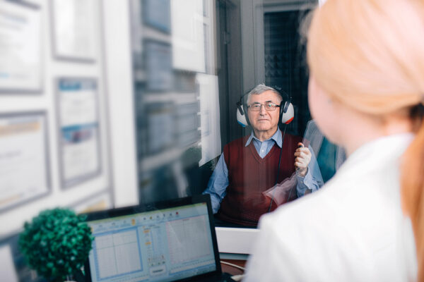 service assesments image@2x hearing test senior man in booth female provider