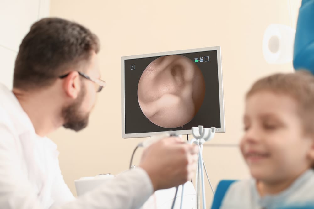 a pediatric ear doctor examaning his patients inner ear