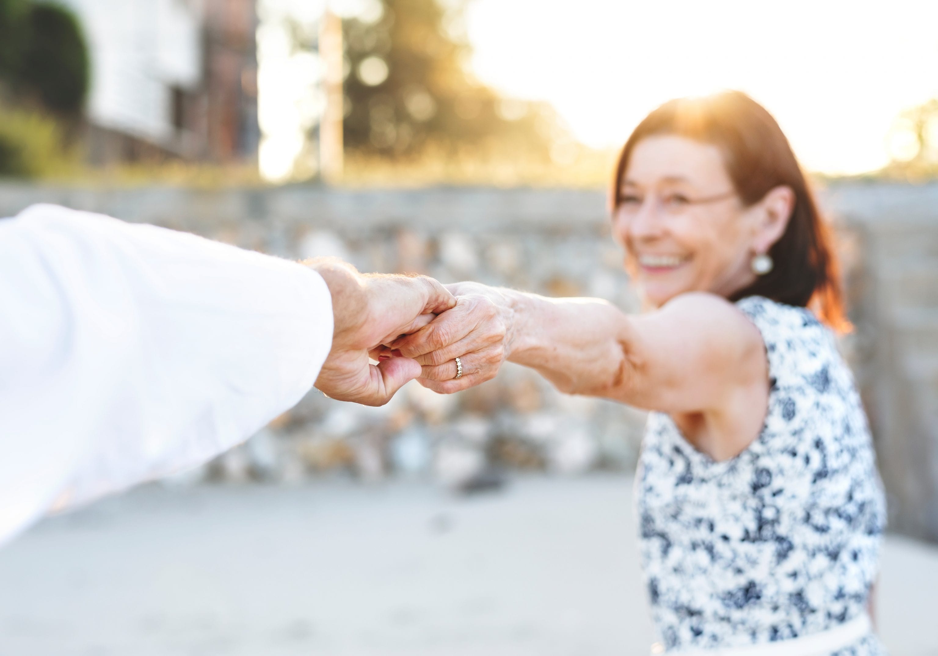 a woman holding the outstretched hand of her spouse