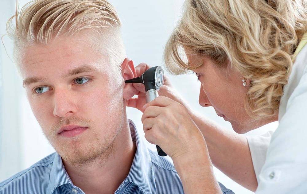a young gentleman having his ears examined