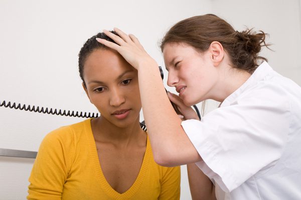 hearing specialist performing hearing evaluation on her patient