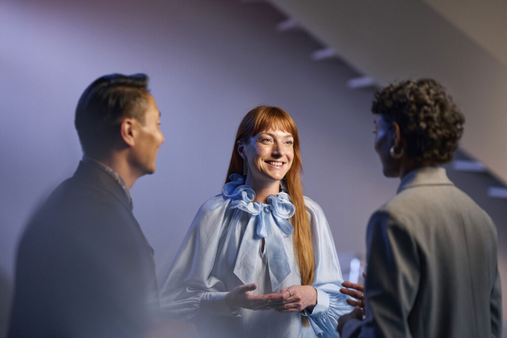 ReSound Vivia lifestyle hearing aid users talking in small group smiling ReSound Vivia lifestyle hearing aid users talking in small group smiling