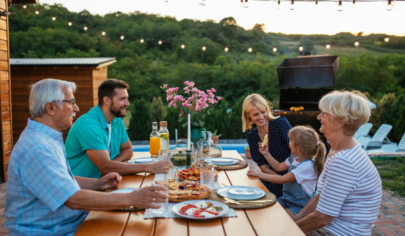 family gathered at a picnic table for dinner