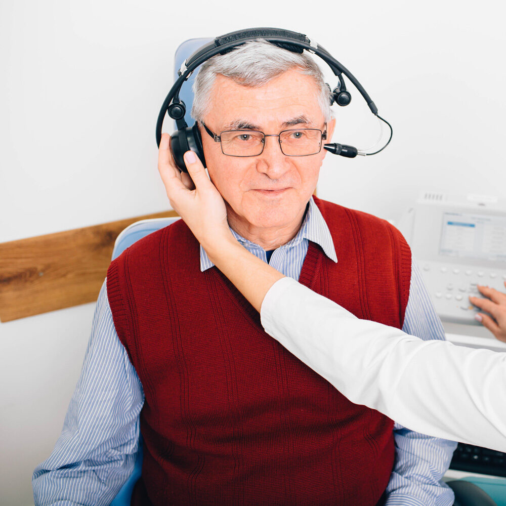 senior man taking a hearing evaluation with hearing care professional