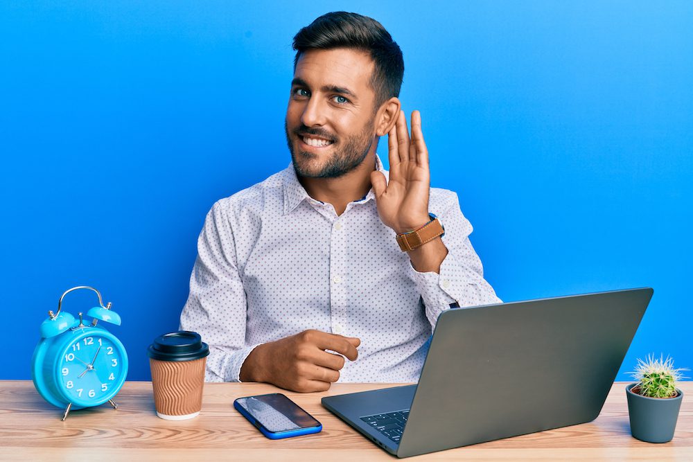 man sitting at desk working on laptop