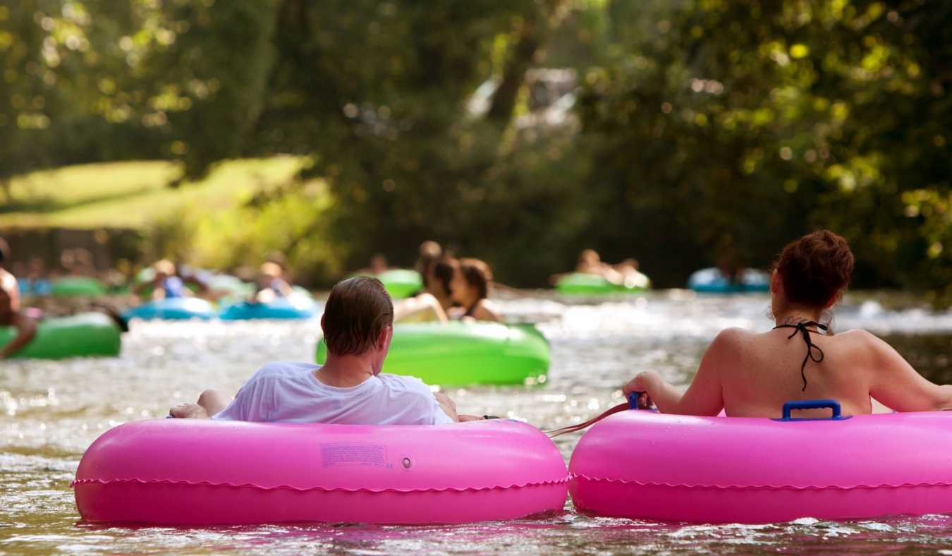 A couple enjoys tubing down the river