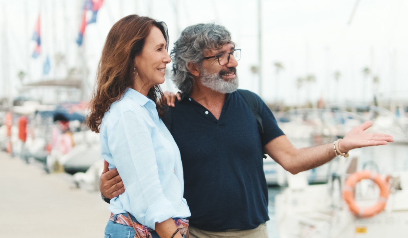 elderly couple walk around boat piers talking