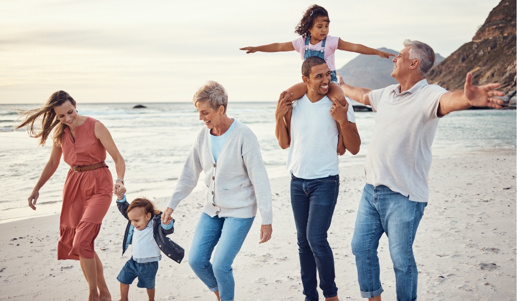 summer diverse family walking alongside beach grandparents