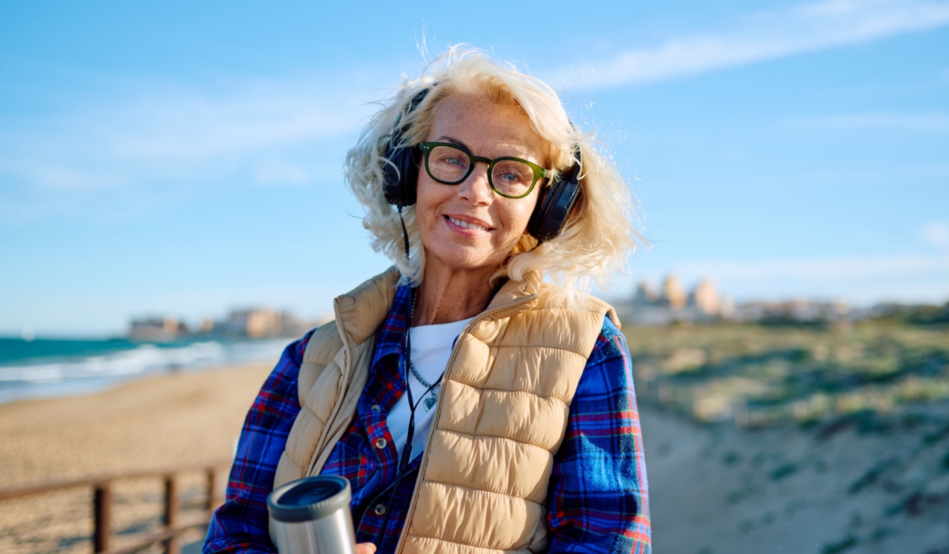 mature woman smiling on chilly beach afternoon