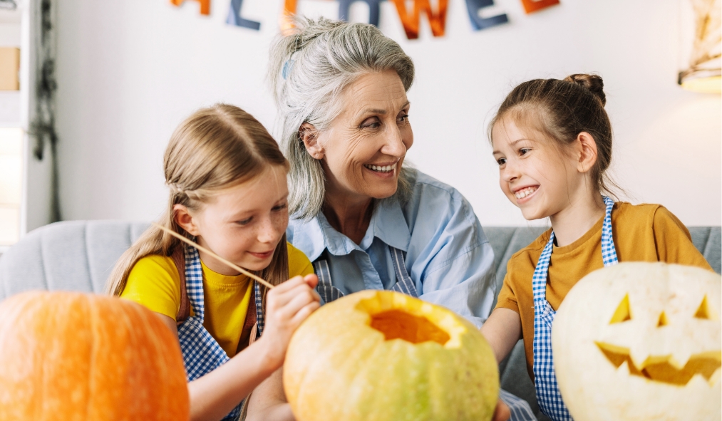 events halloween grandmother decorating pumpkins with granddaughters