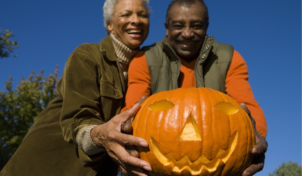 events halloween senior black couple holding pumpkin carved