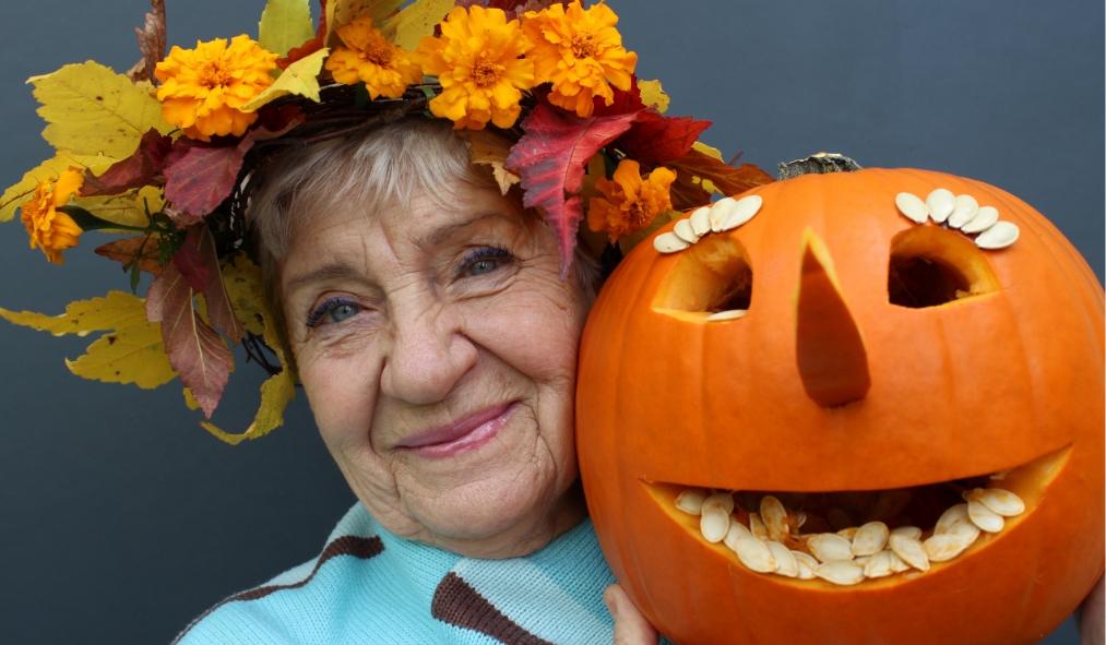 events halloween senior women wearing leave flower crown posing with carved pumpkin