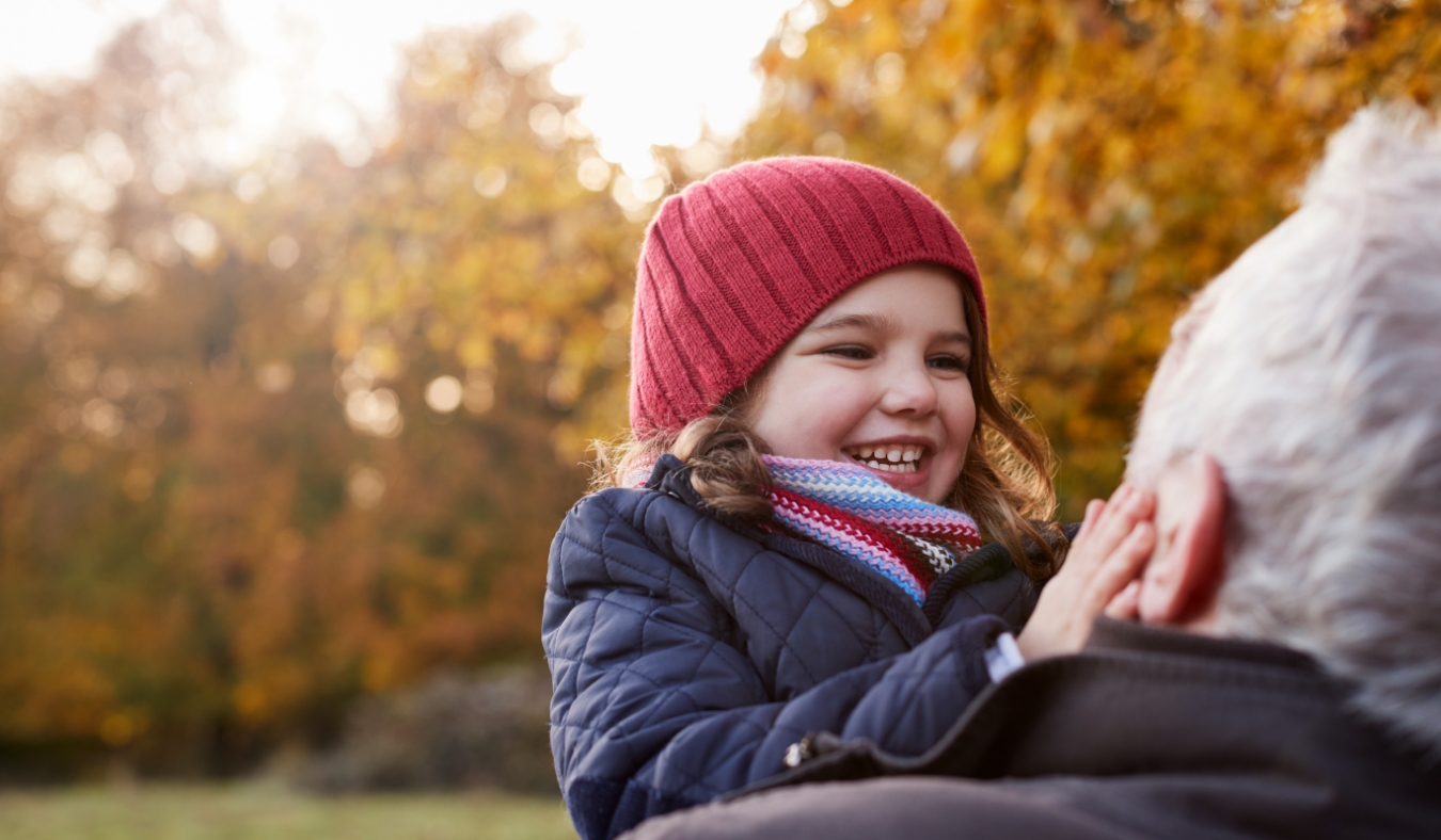 granddaughter playing outside autumn with grandfather