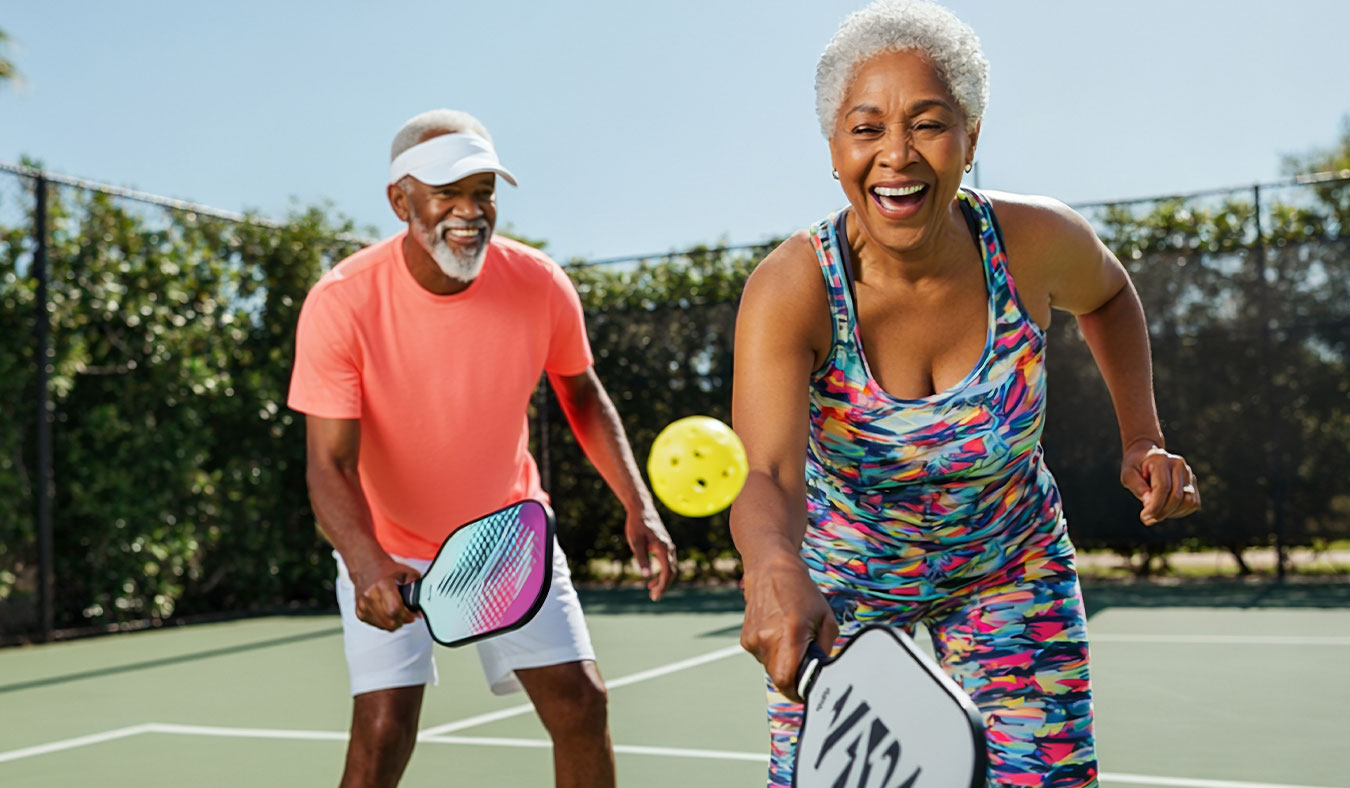 events black senior couple playing pickleball
