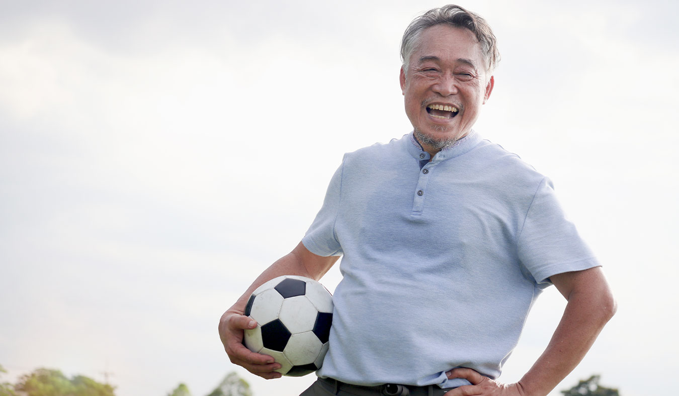 events senior asian man holding soccerball smiling