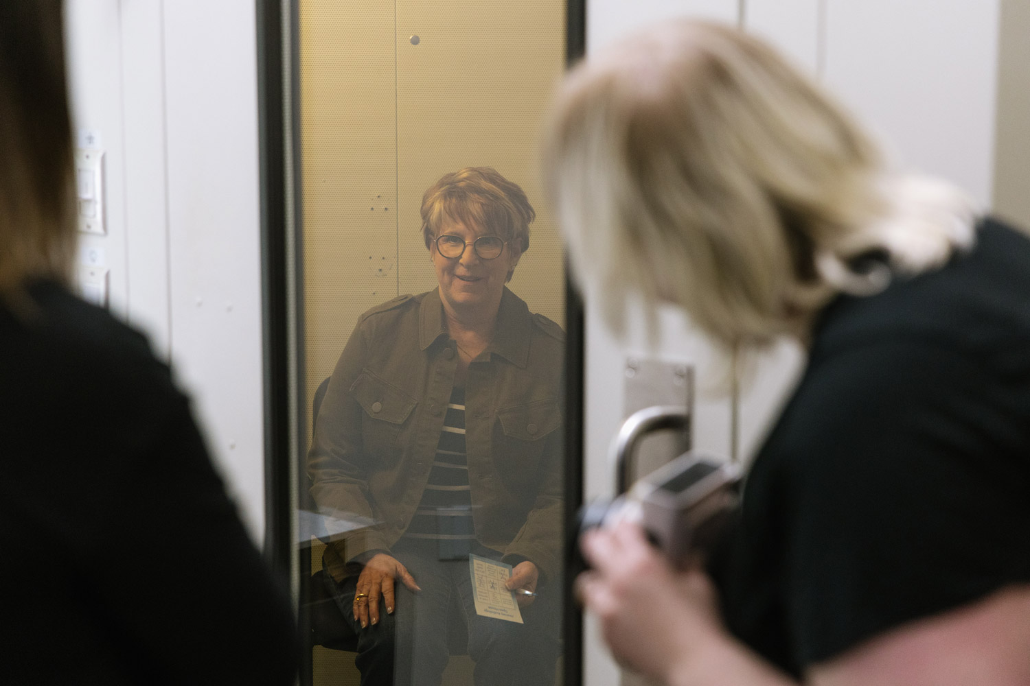 dr rachel performing hearing evaluation in sound booth