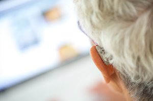back of mans head hearing aid in ear
