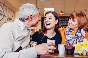 daughter eating dinner with parents at restaurant