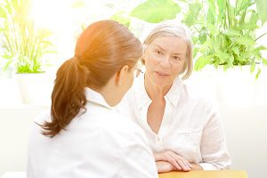 elderly woman in sunshine outside wearing all white