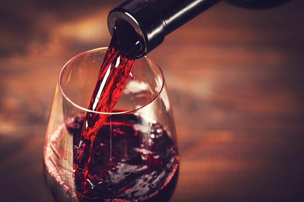 red wine being poured into glass from bottle