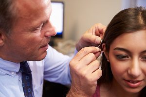 audiologist fitting patient for new hearing aids