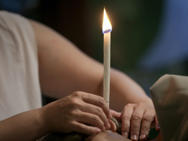 a lit candle held by a hand
