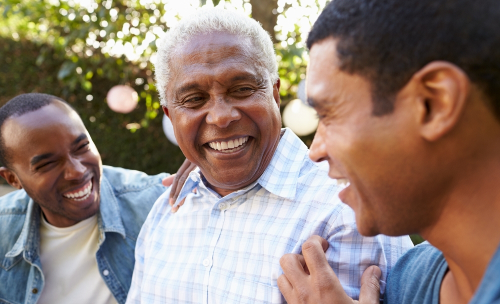 black father laughing with adult sons