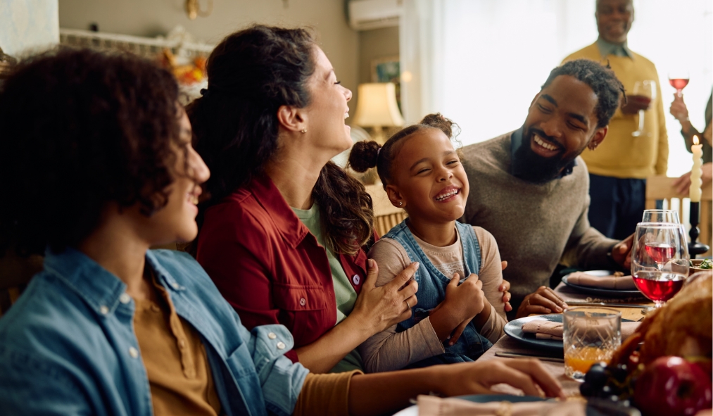 events thanksgiving family friends gathered around table laughing