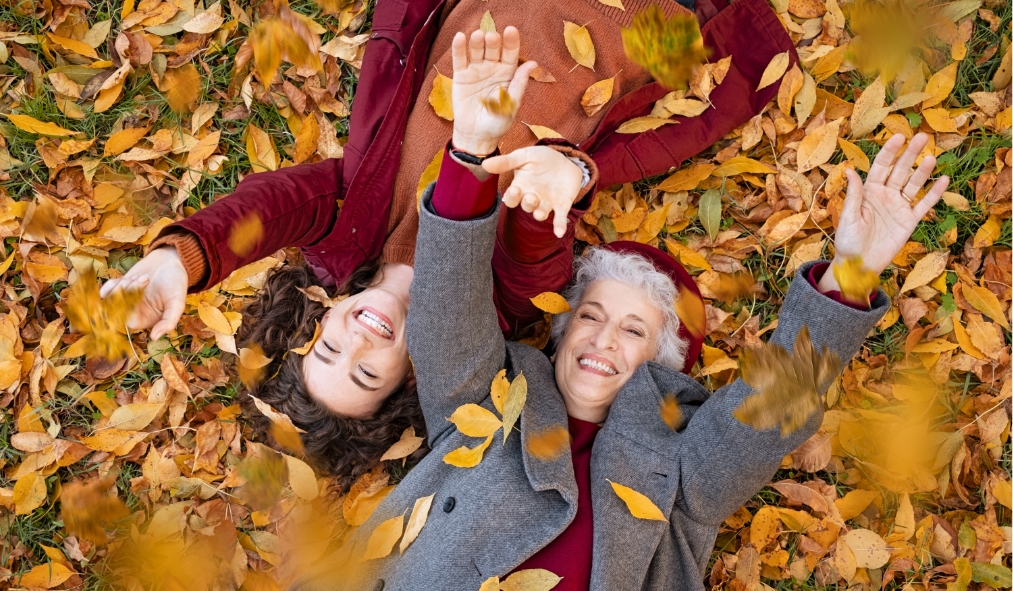 events autumn granddaughter grandmother lying playing in fall leaves
