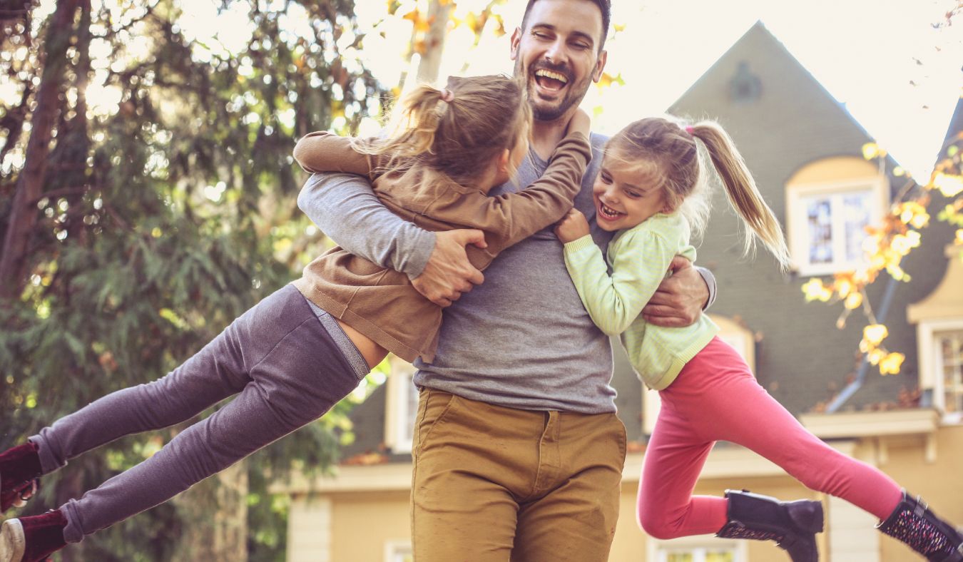 father holding daughters