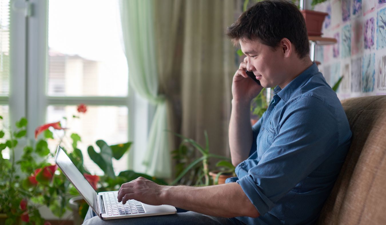 young man on phone and laptop