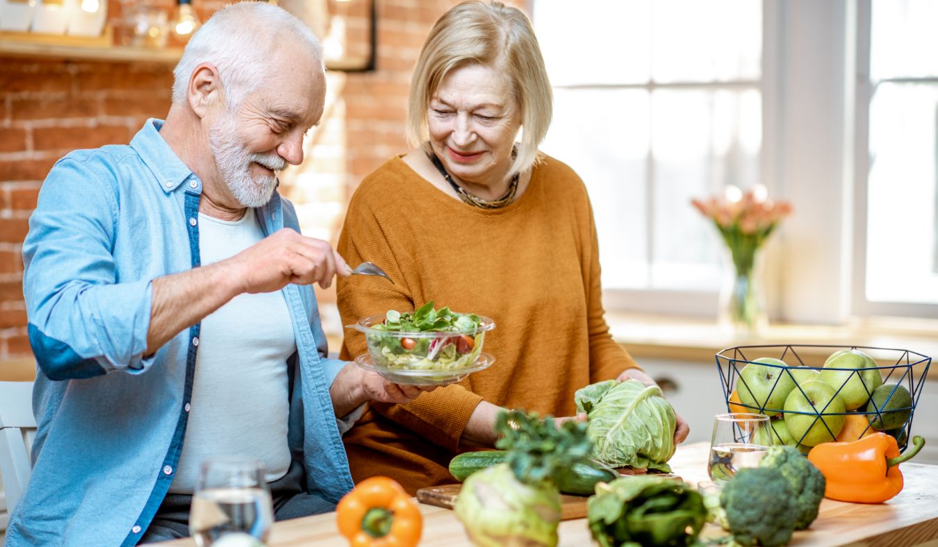 older couple preparing salad