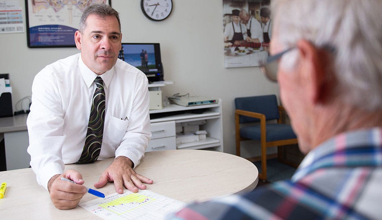 hearing instrument specialist discussing hearing challenges with patient