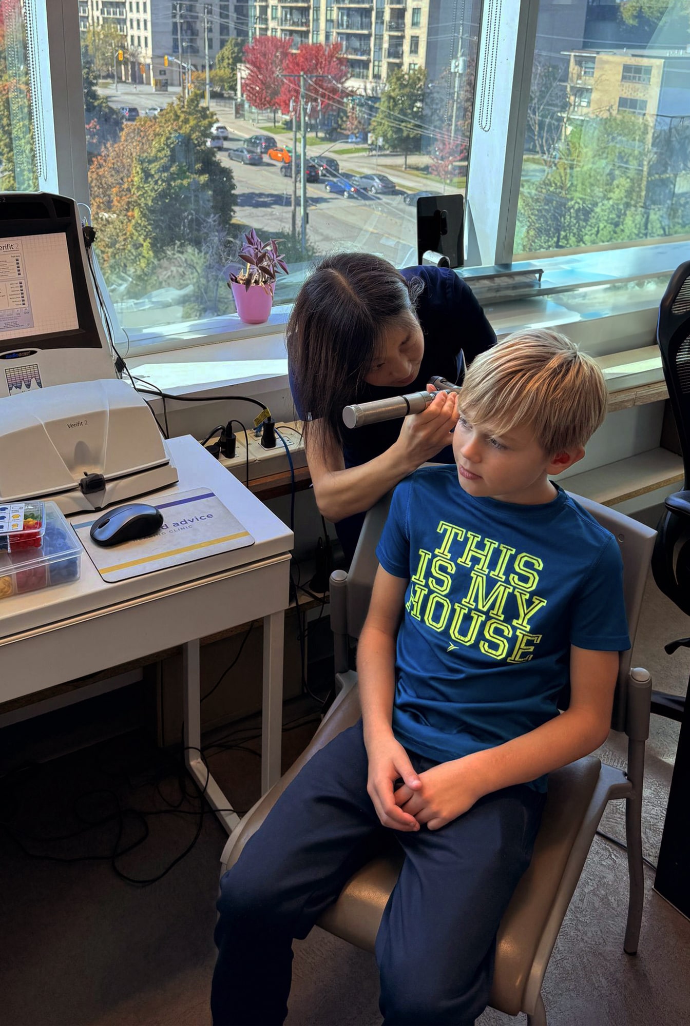 hearing provider checking ear of young boy