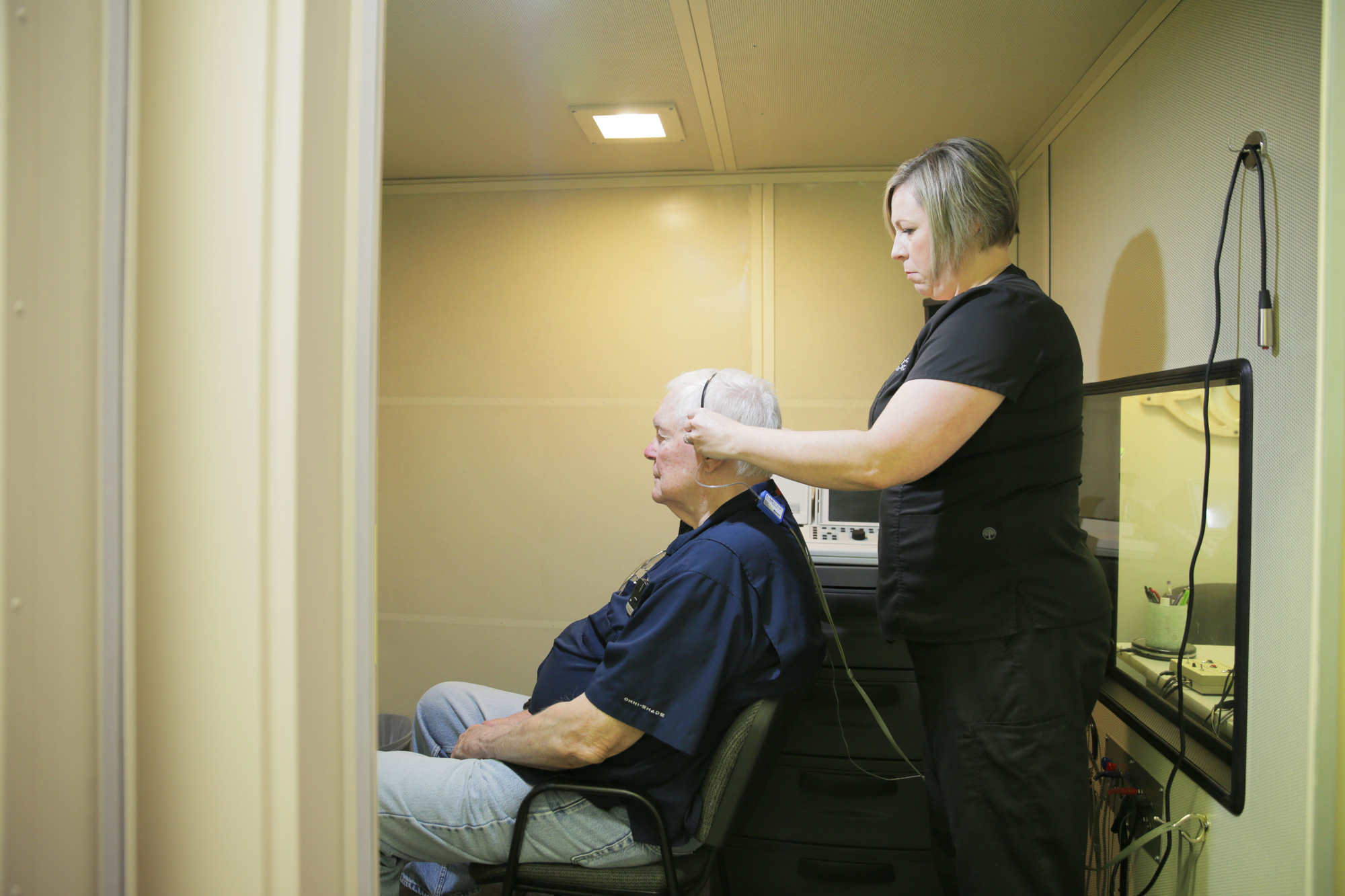 provider assisting patient with technology for hearing evaluation