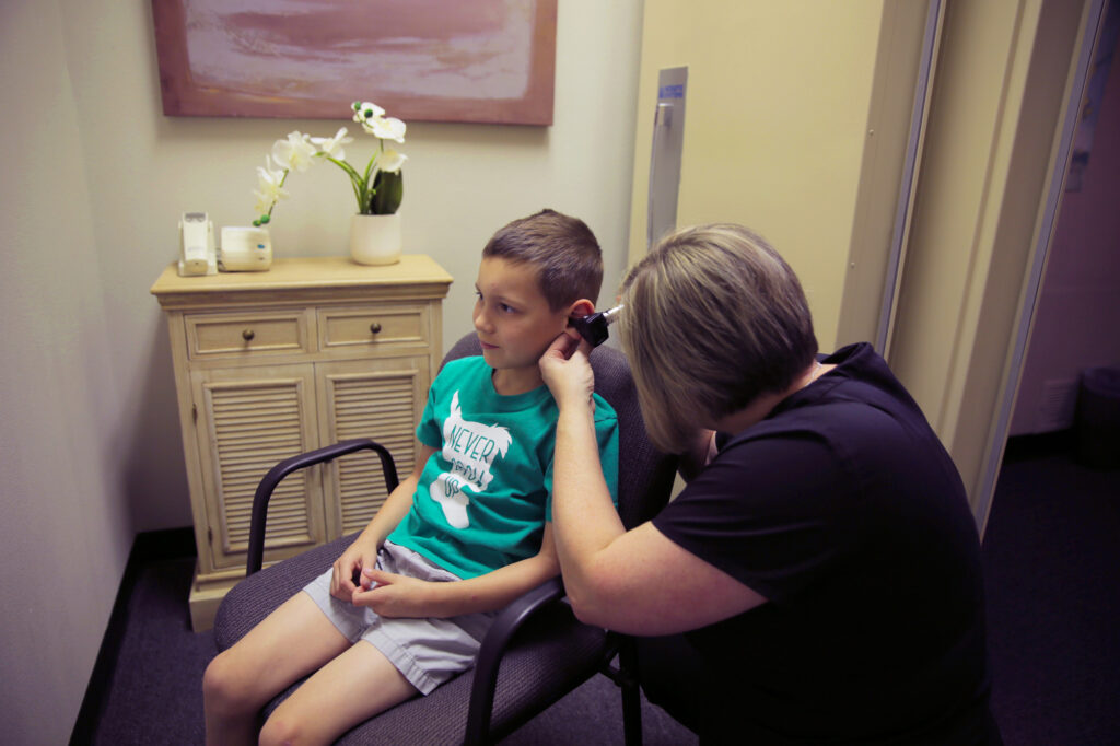 provider looking in child patient ear with otoscope