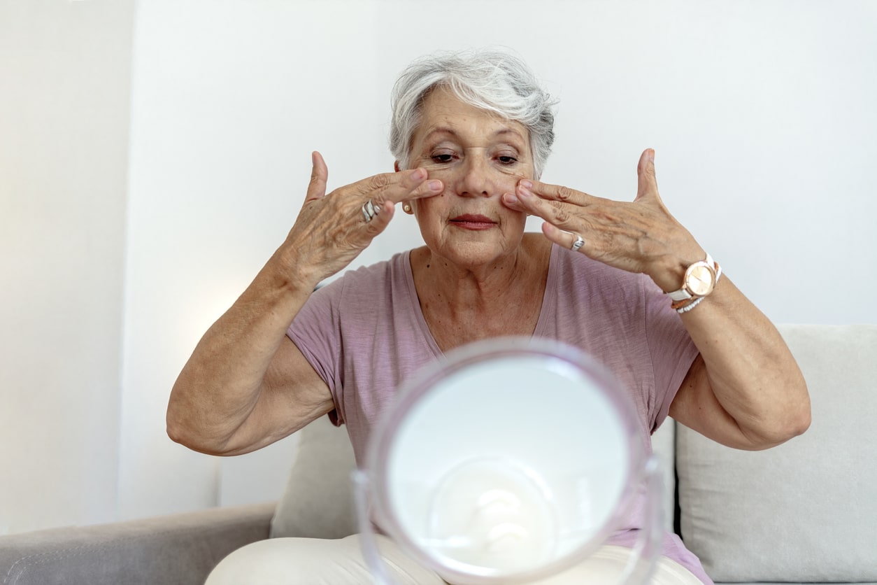 Senior woman putting on makeup