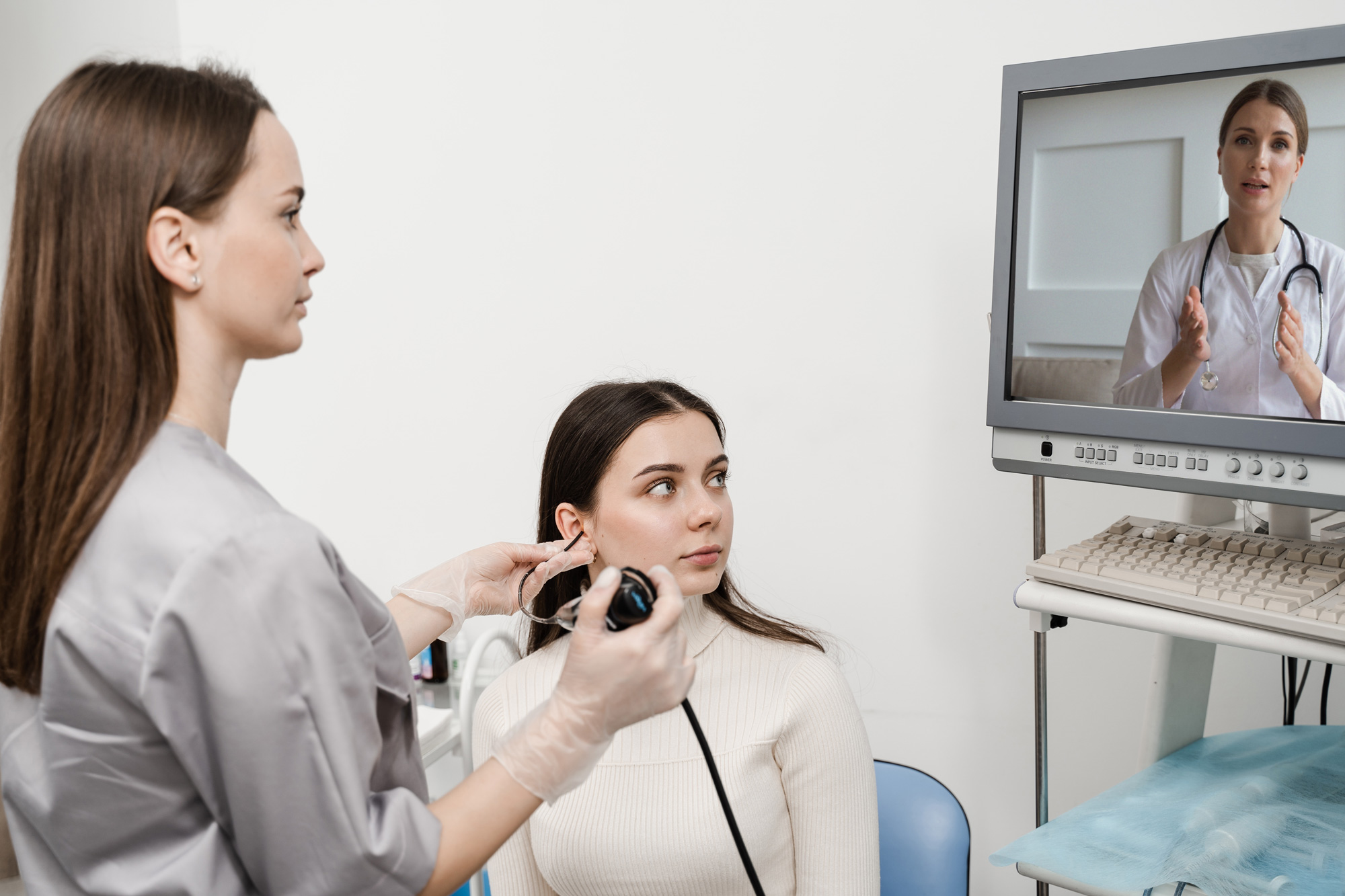 ent provider evaluating ear with audiologist providing telehealth appointment
