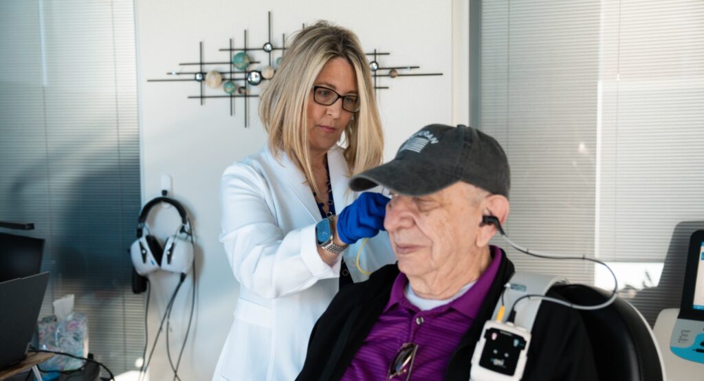 Dr Alegria performing hearing test in office with patient