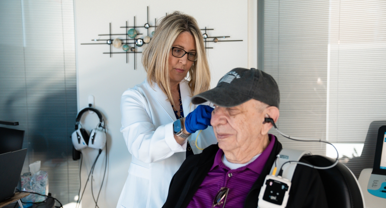 Dr Alegria performing hearing test in office with patient