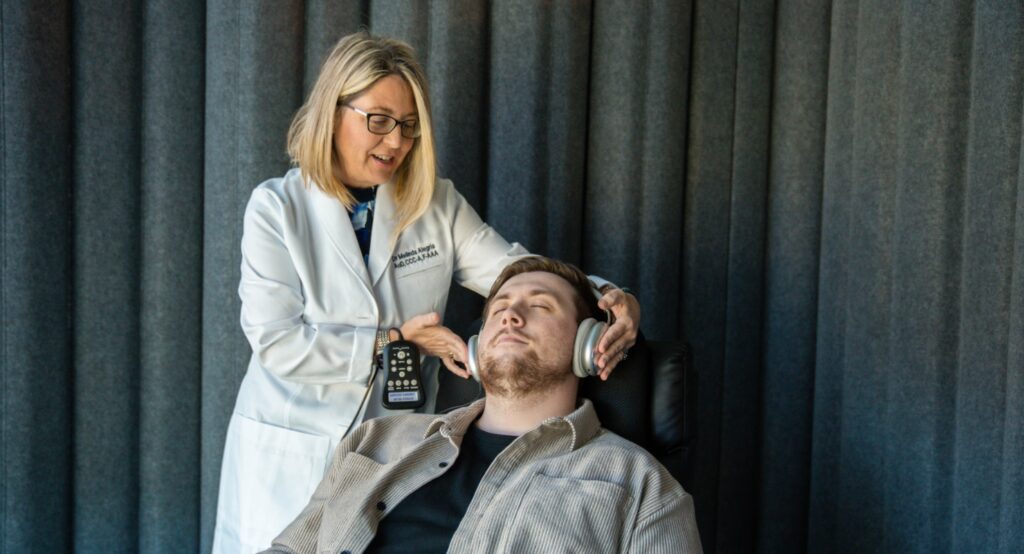 dr alegria helping a patient during acoustic spa appointment