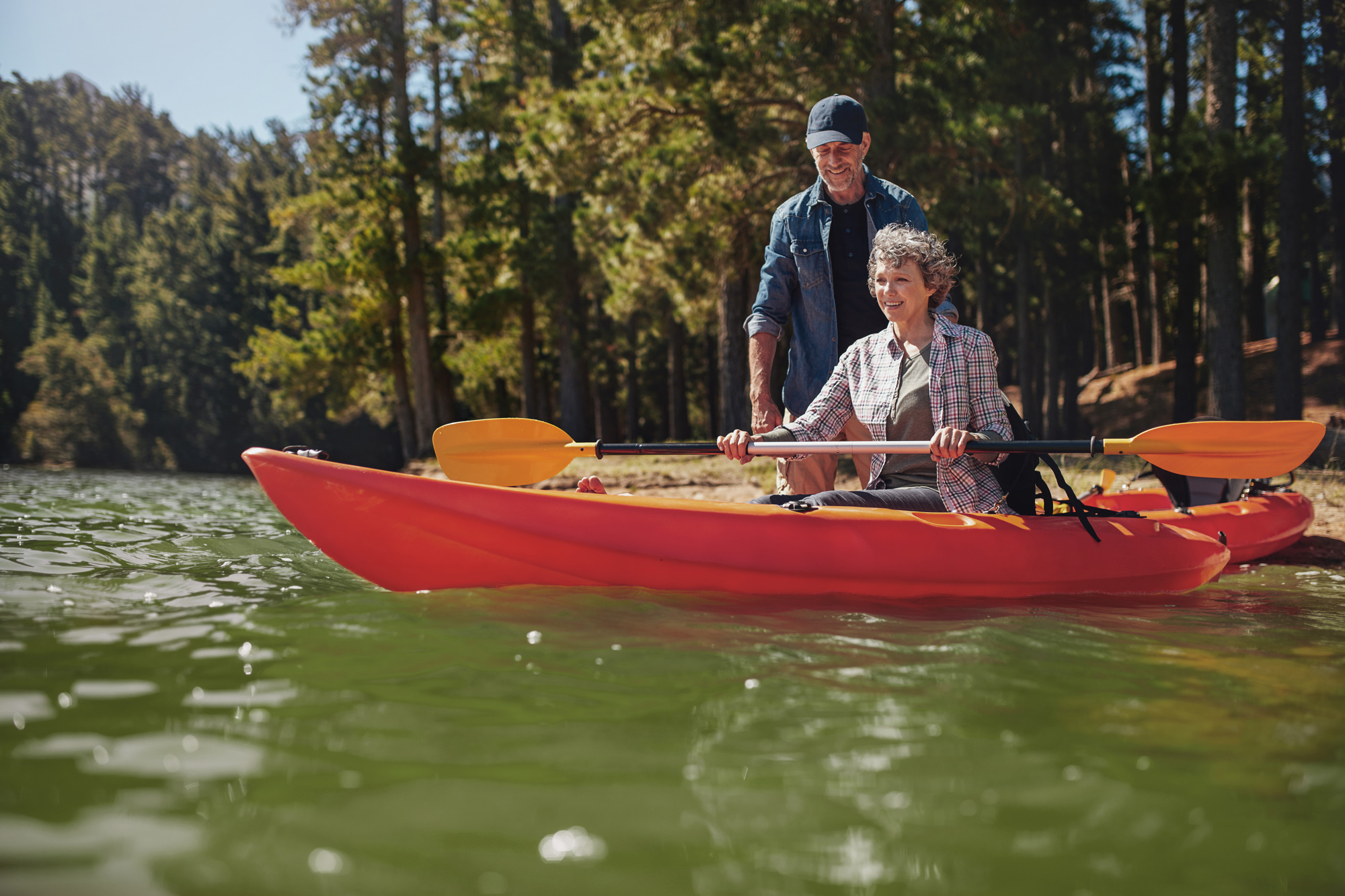 older man teaching older woman how to kayak