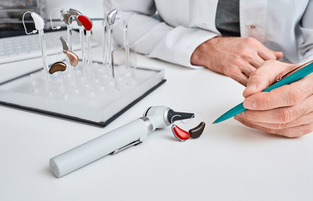 Audioprosthetist,Presentation,Hearing,Aids,In,Two,Colors,To,His,Patient