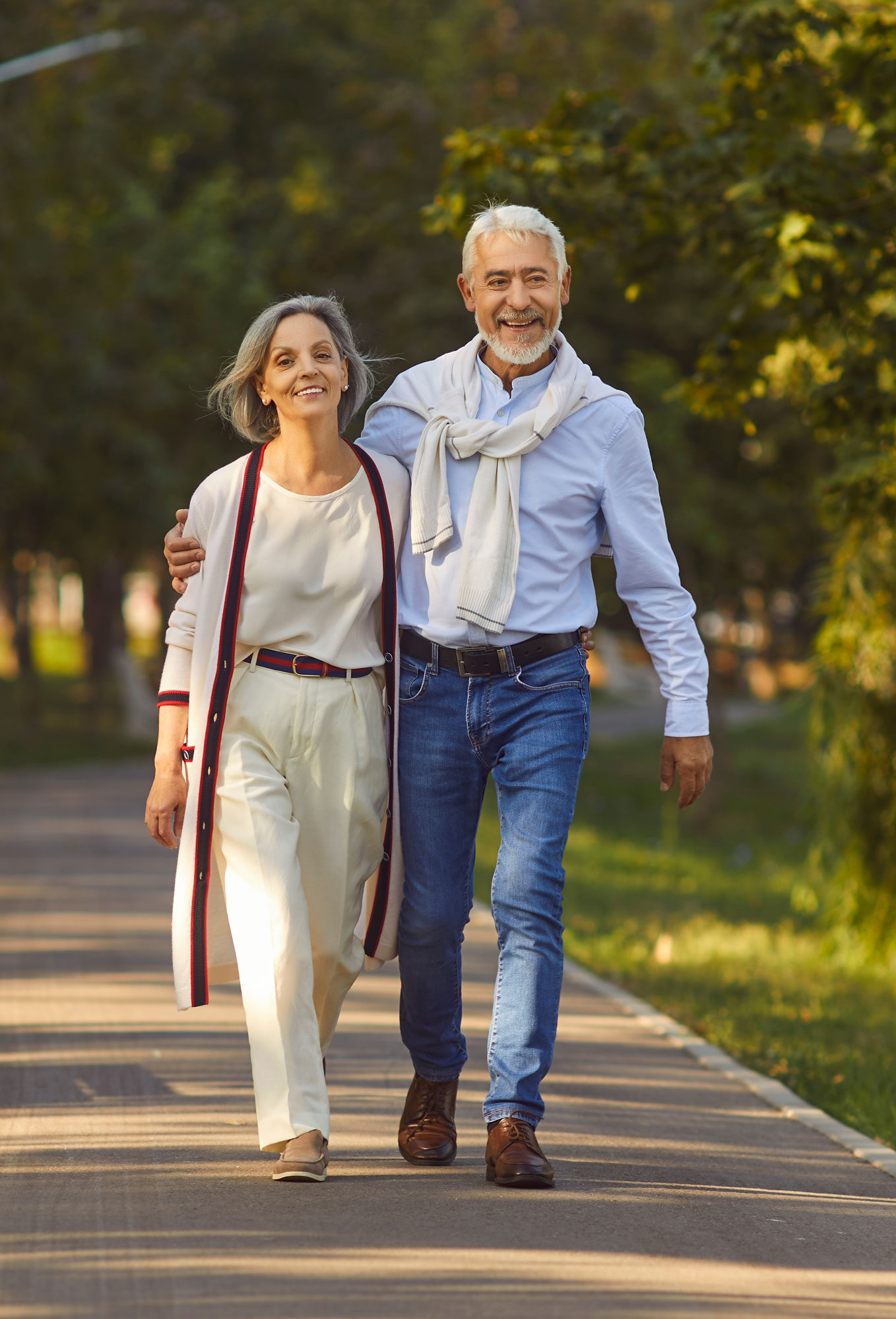 older couple walking down park path