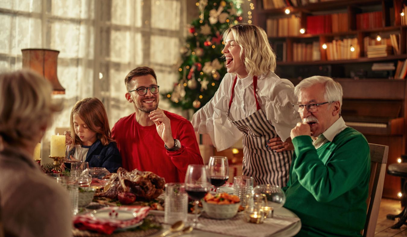 blog christmas family gathered around table laughing