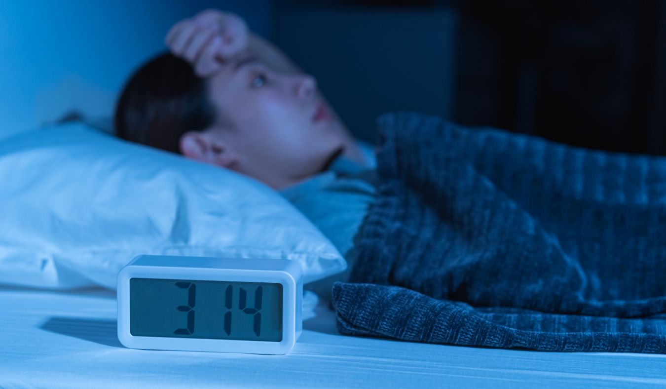 stress women laying in bed unable to sleep