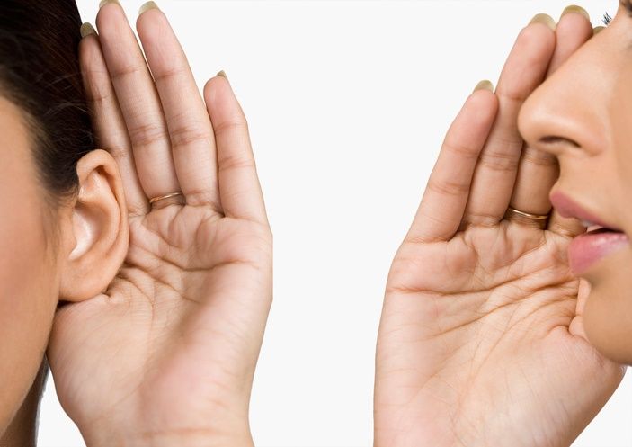 two people with hands to ears