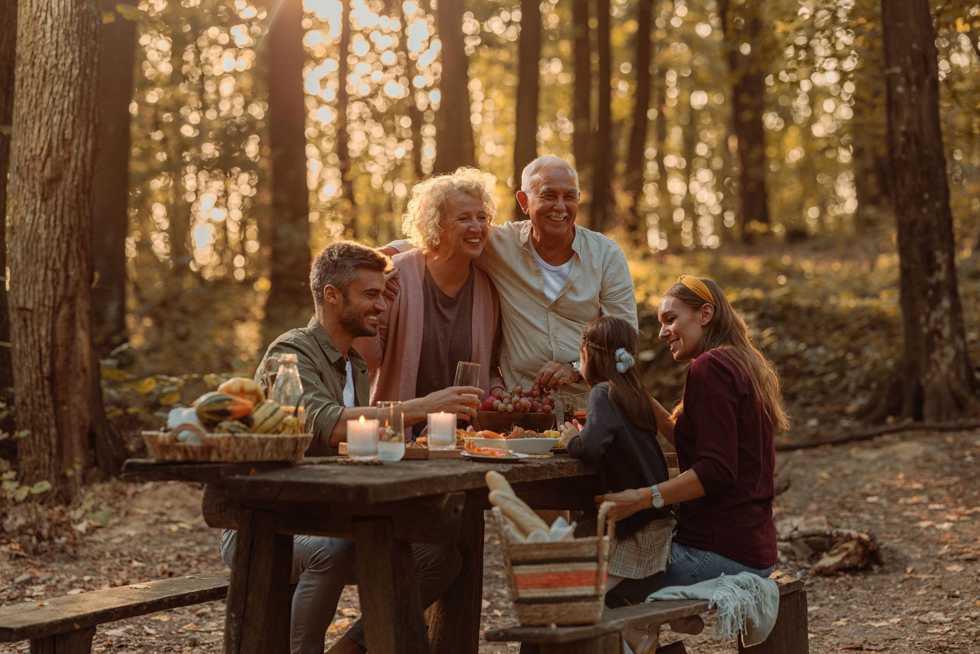 grandparents parents grandchildren enjoying outdoor meal in forest